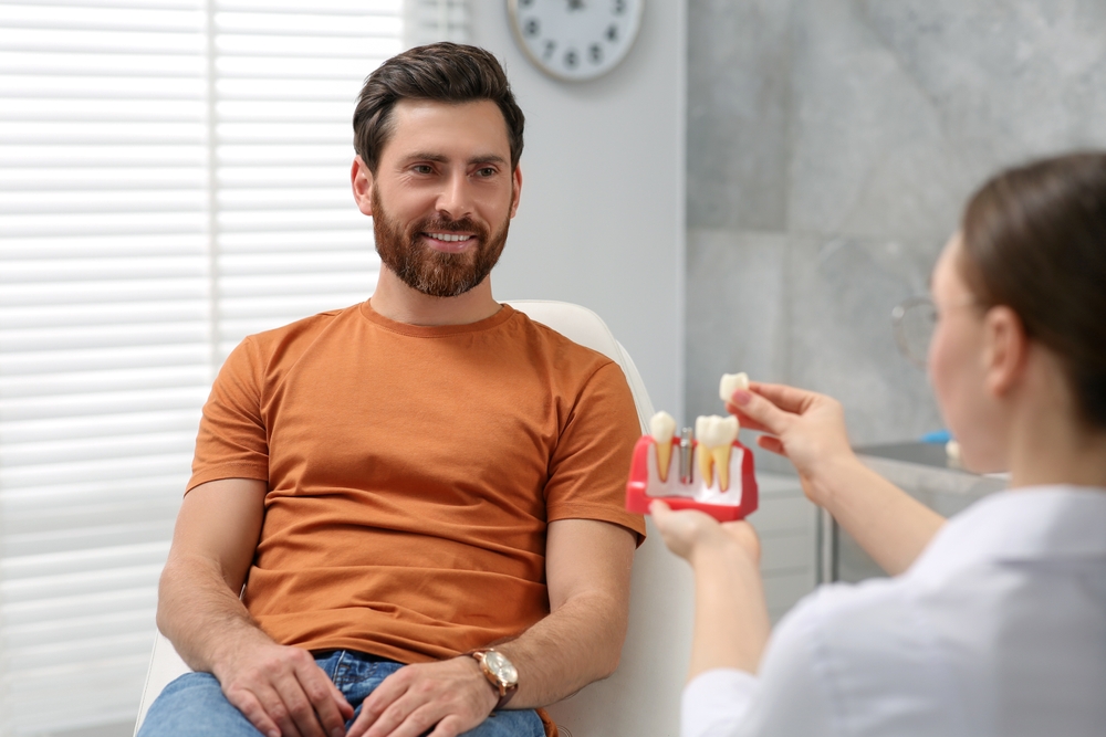 Doctor,With,Educational,Model,Of,Dental,Implant,Consulting,Patient,In Doctor,With,Educational,Model,Of,Dental,Implant,Consulting,Patient,In