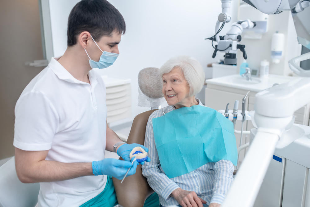 Male,Dentist,Talking,To,His,Senipr,Patient,And,Explaining,Her Male,Dentist,Talking,To,His,Senipr,Patient,And,Explaining,Her