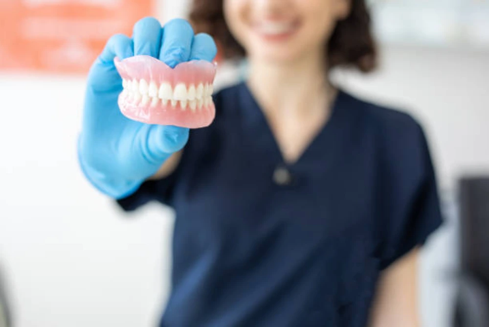 dentist showing dentures for missing teeth replacement treatment